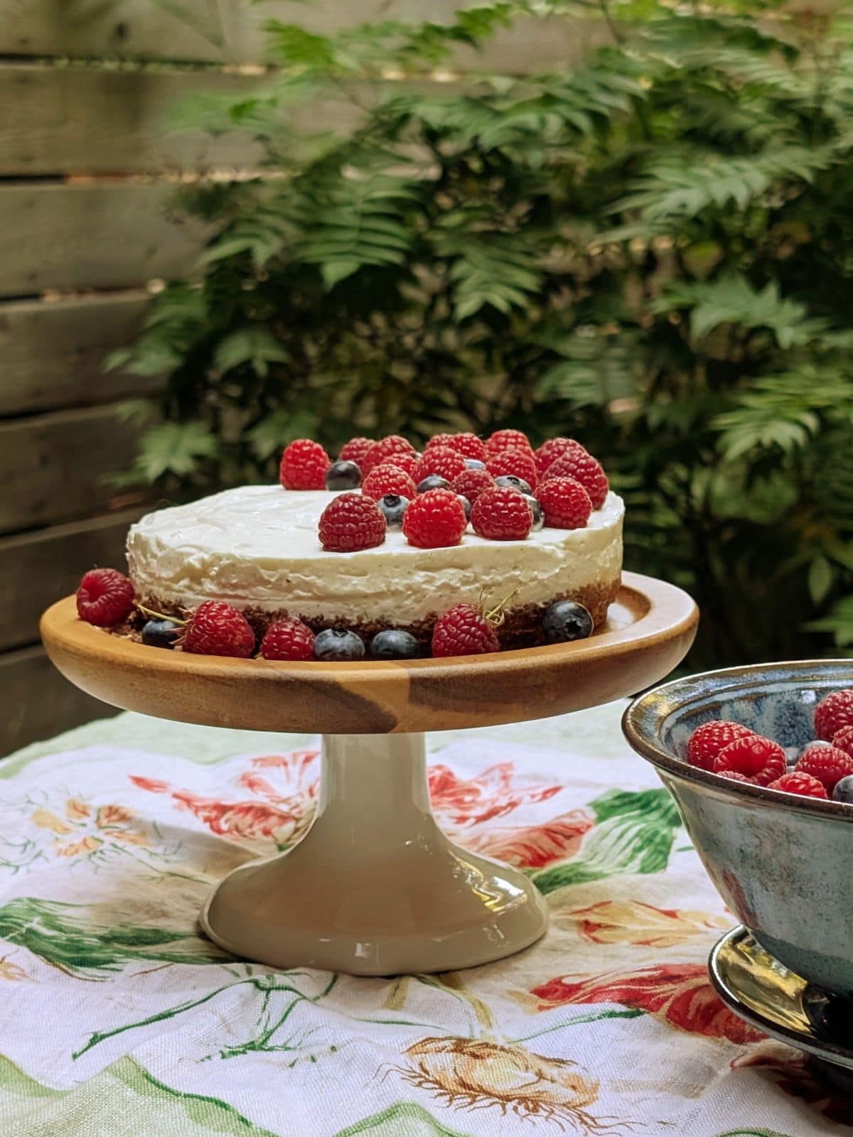Un cheesecake  sur une table et un bol de petits fruits
